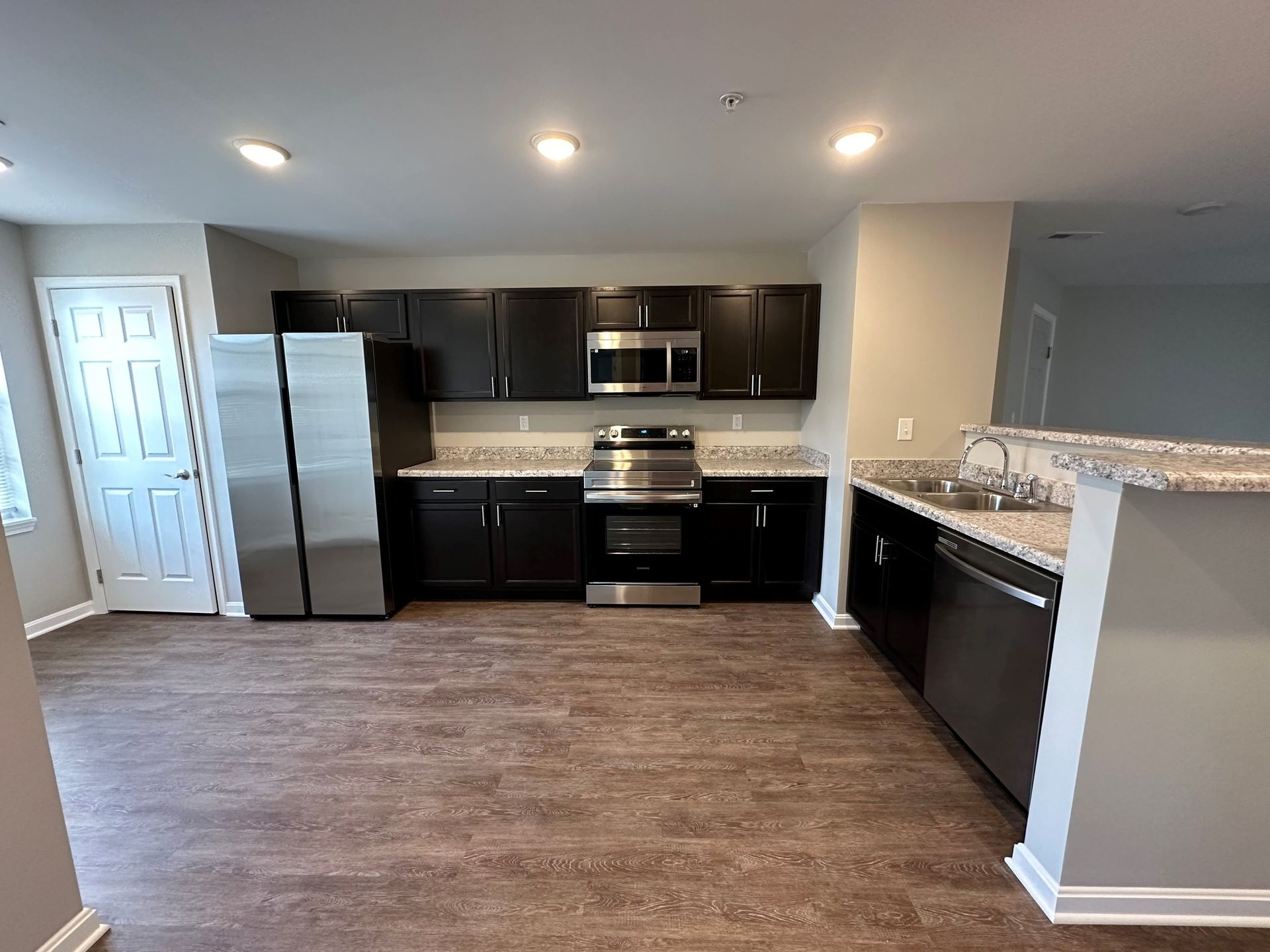 A kitchen with stainless steel appliances and black cabinets