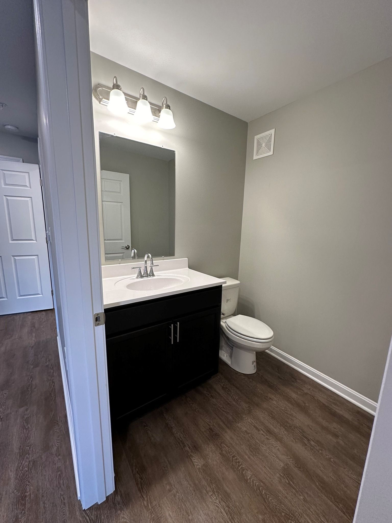 A bathroom with a sink , toilet and mirror.