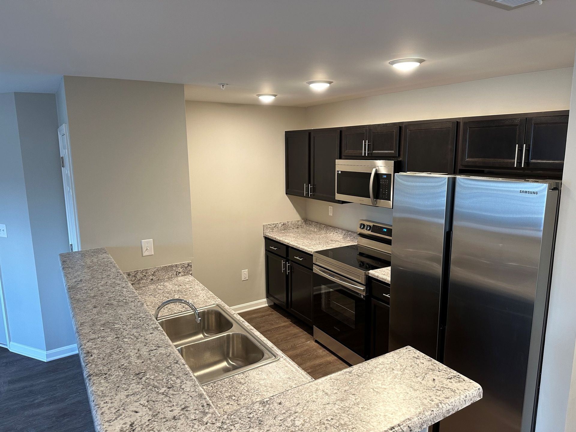 A kitchen with granite counter tops and stainless steel appliances.