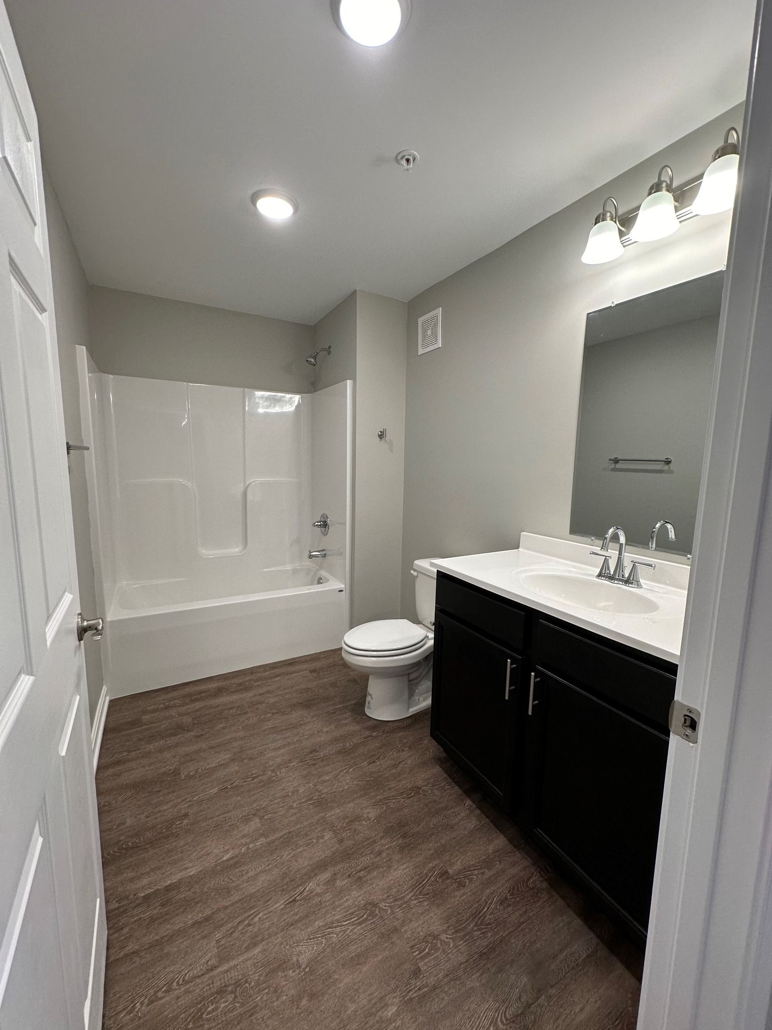 A bathroom with a toilet , sink , and bathtub.