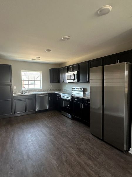 A kitchen with stainless steel appliances and black cabinets