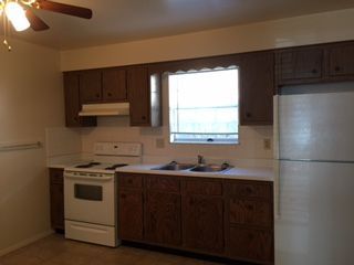 A kitchen with brown cabinets and a white refrigerator