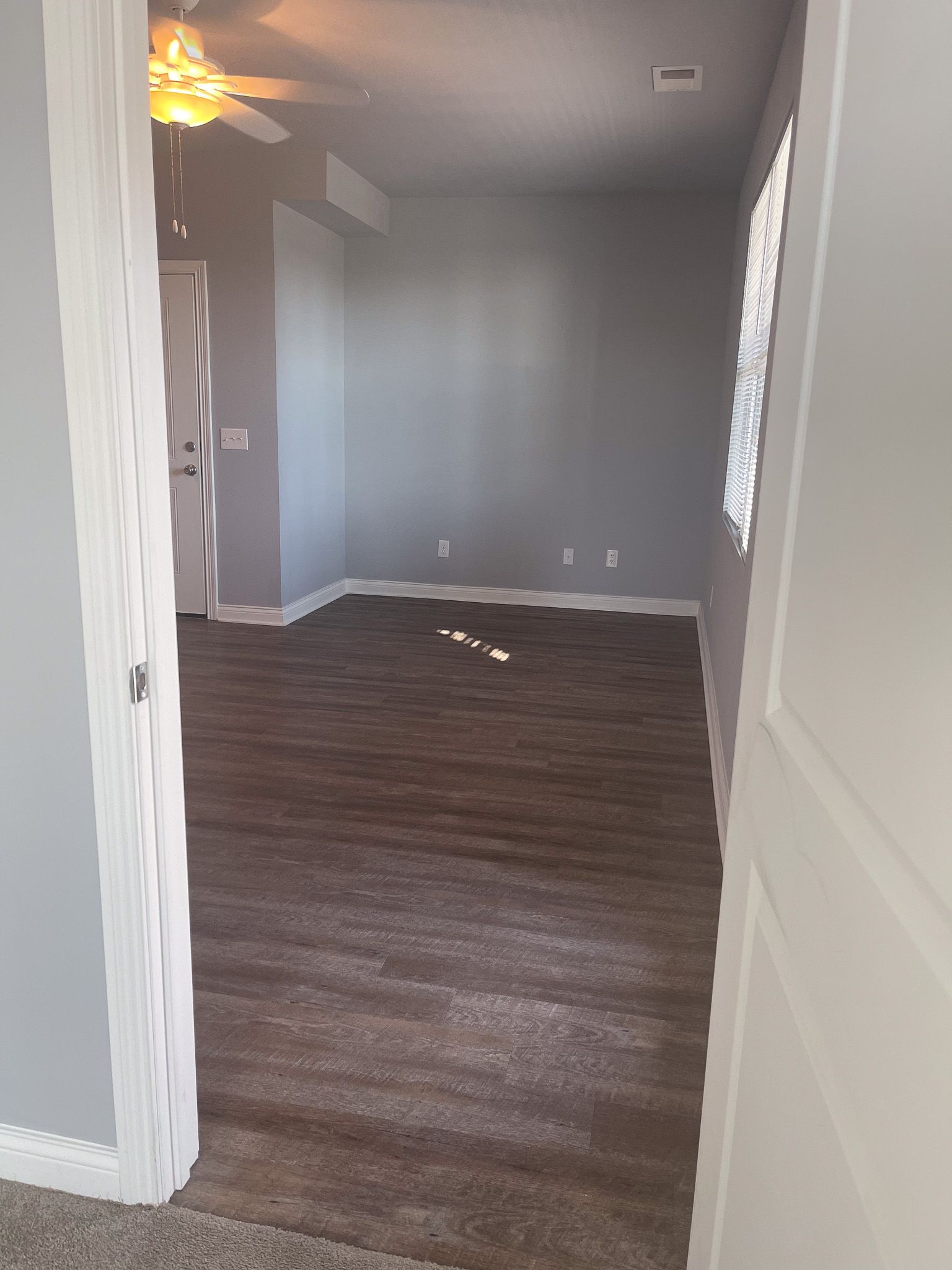 There is a ceiling fan in the room and a carpeted floor.