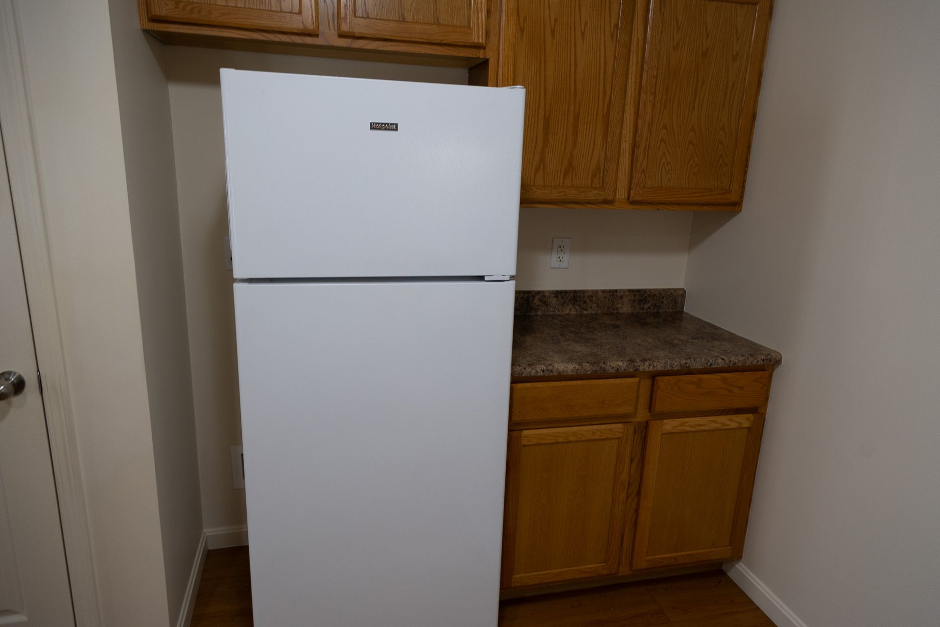 A white refrigerator is sitting in a kitchen next to a counter.
