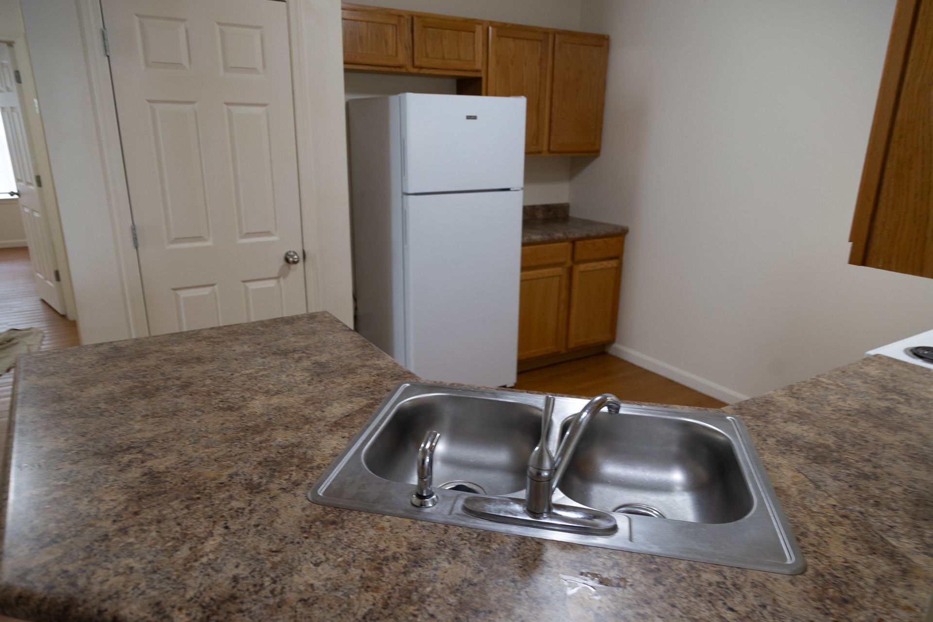 A kitchen with a double sink and a refrigerator