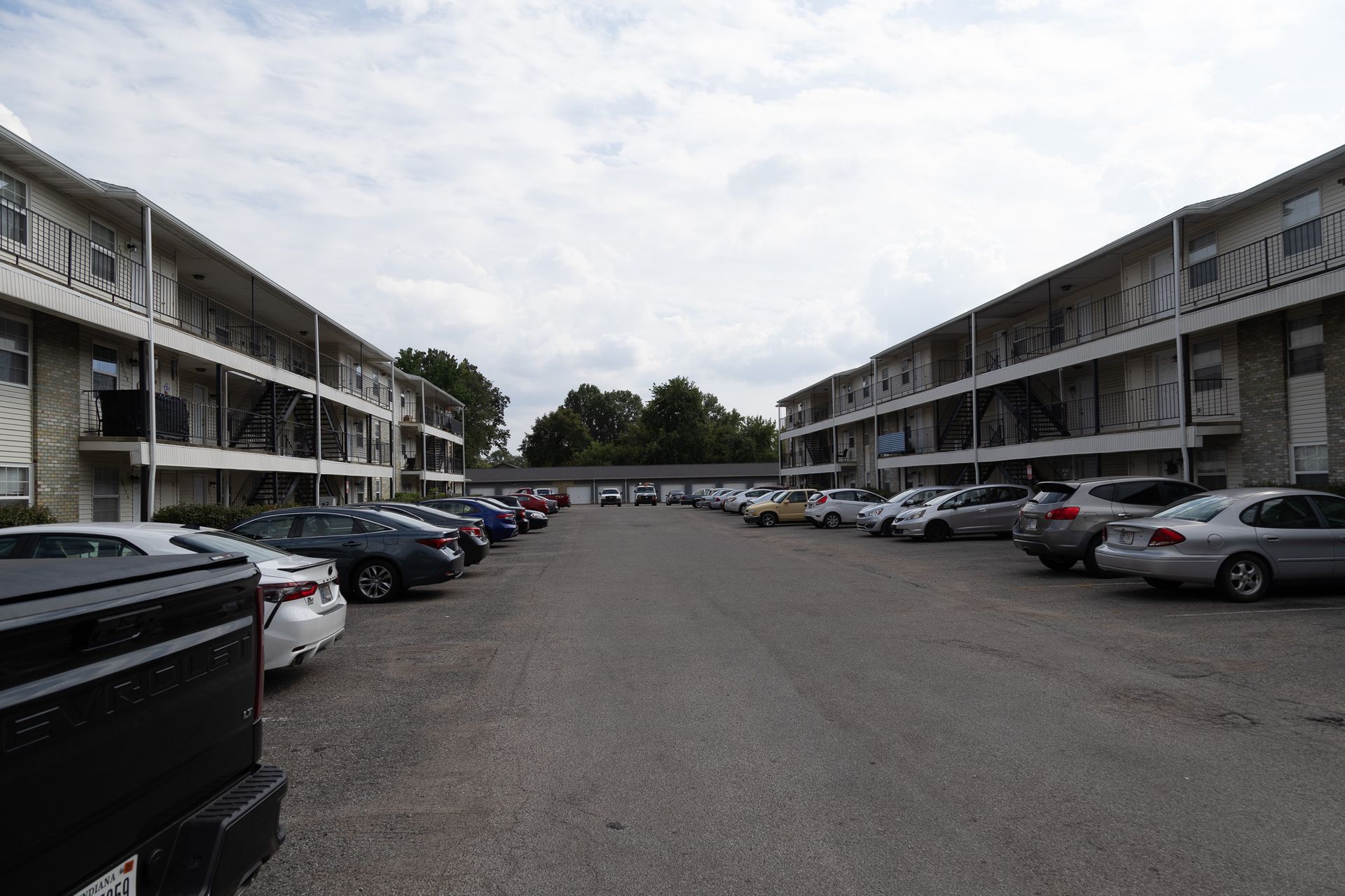 A lot of cars are parked in front of a building.