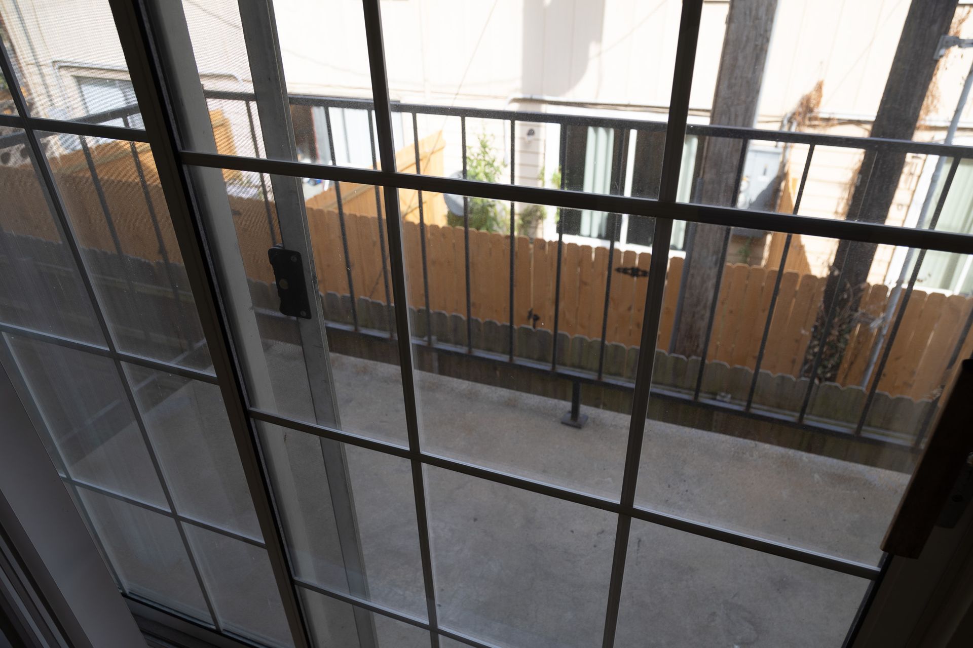 A view of a balcony through a sliding glass door.