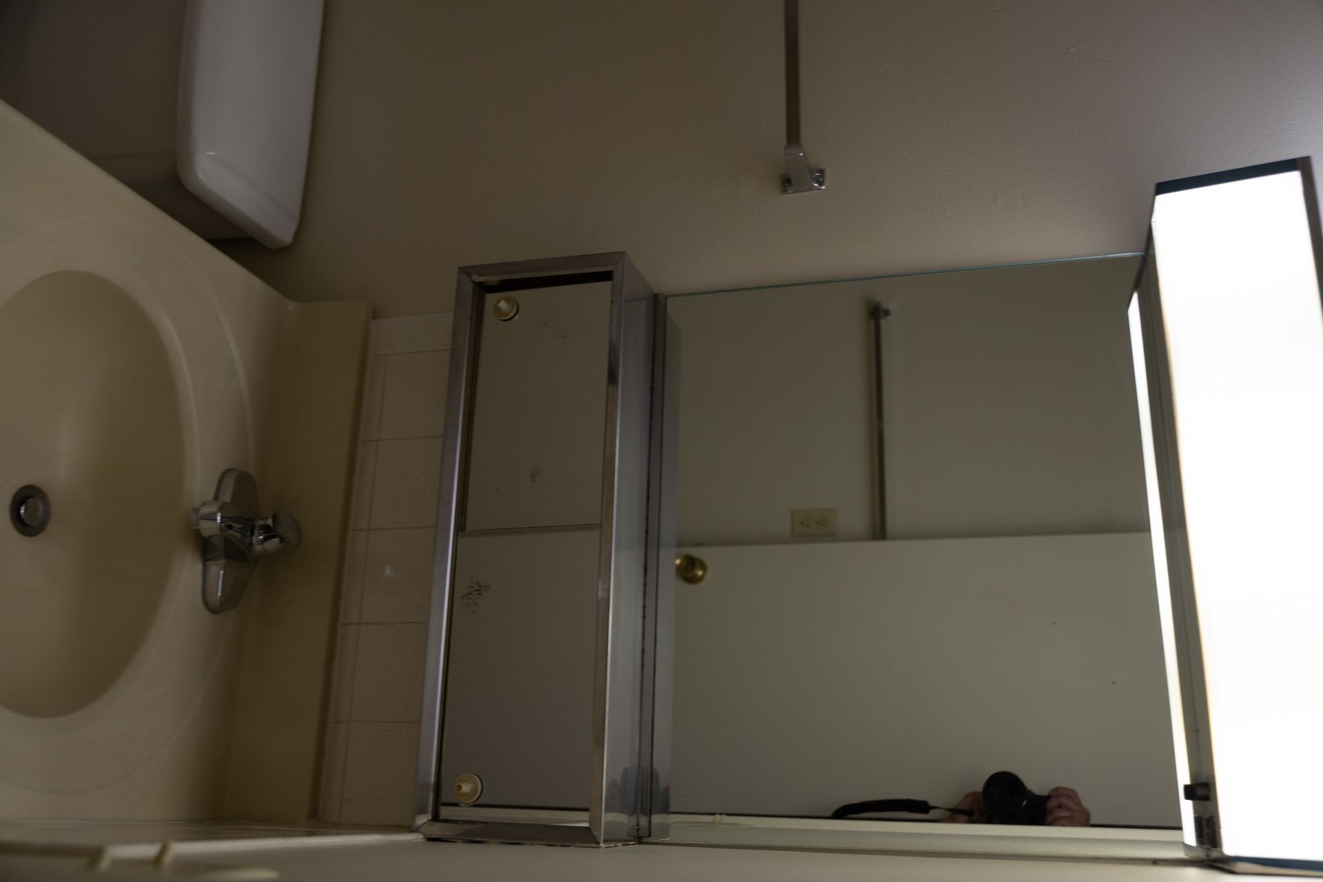 A bathroom with a sink a toilet and a mirror