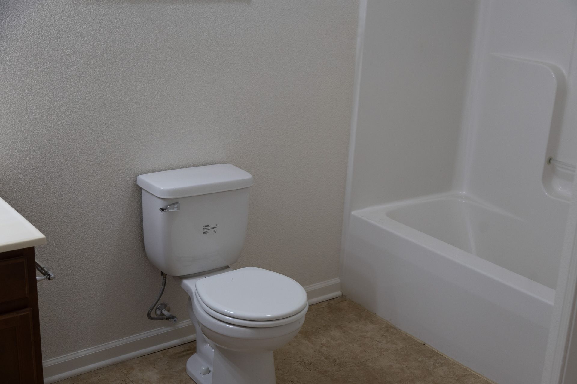 A bathroom with a toilet , sink and bathtub.
