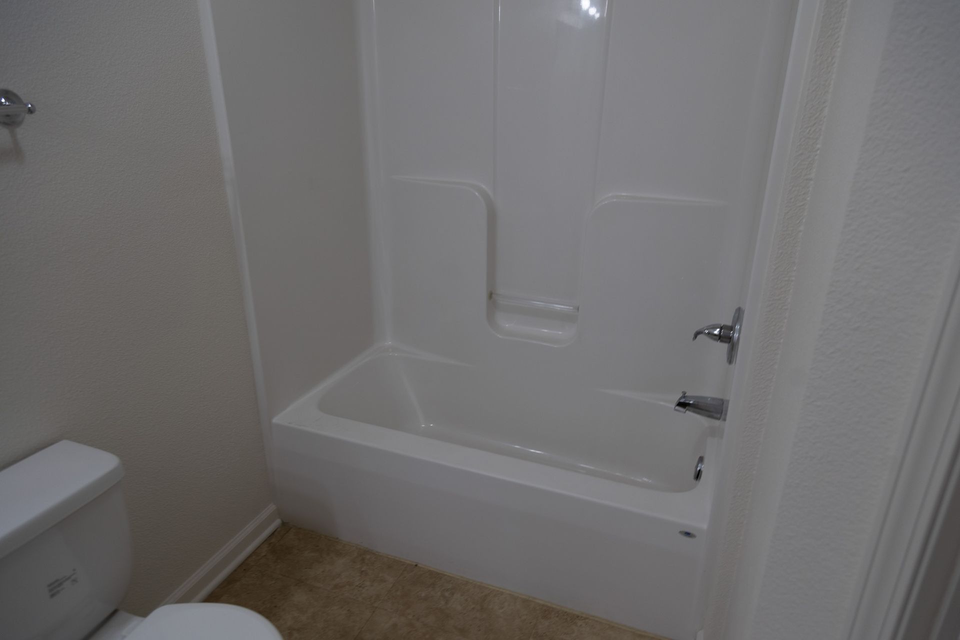 A bathroom with a toilet , bathtub and shower.