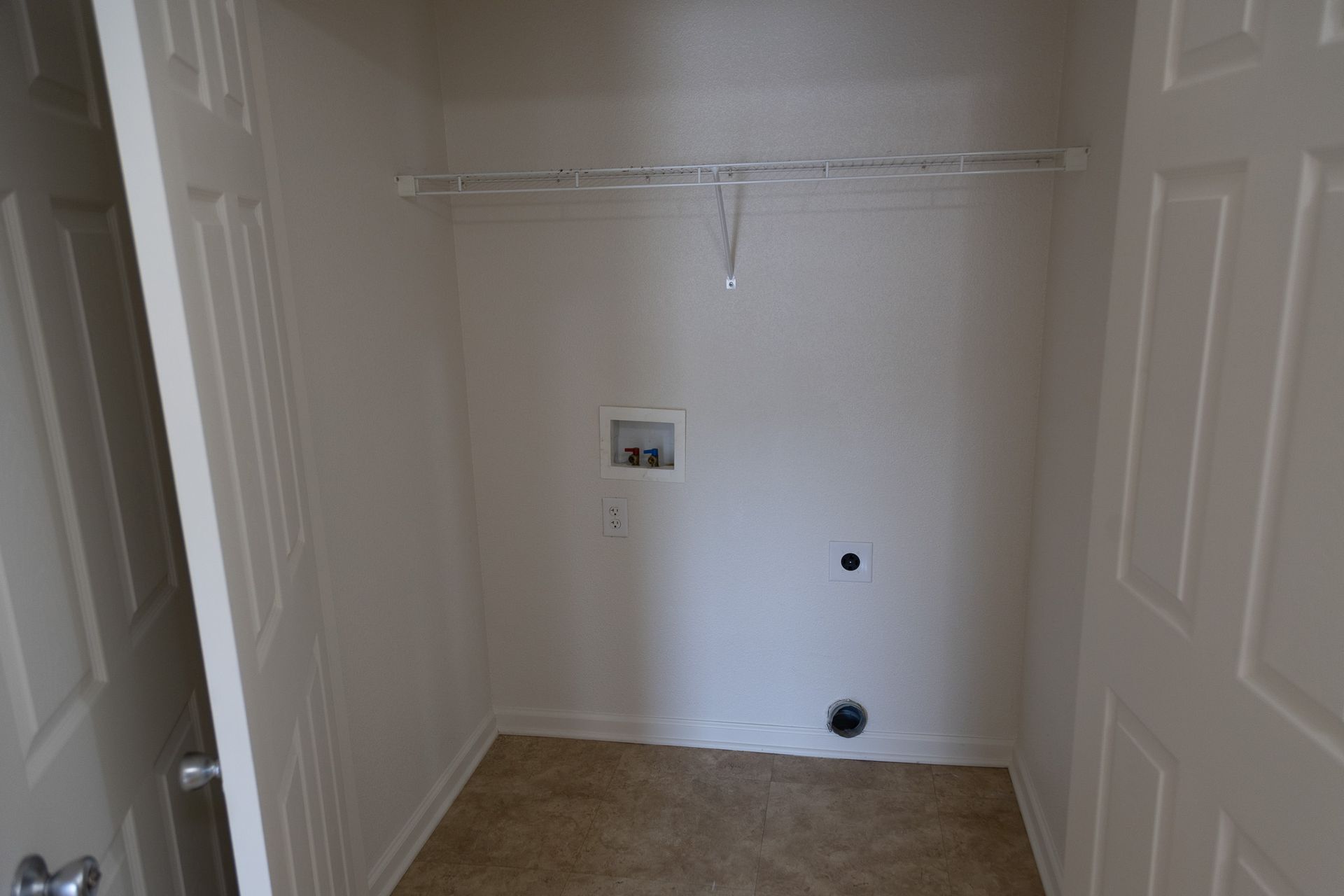 An empty laundry room in a house with a washer and dryer.