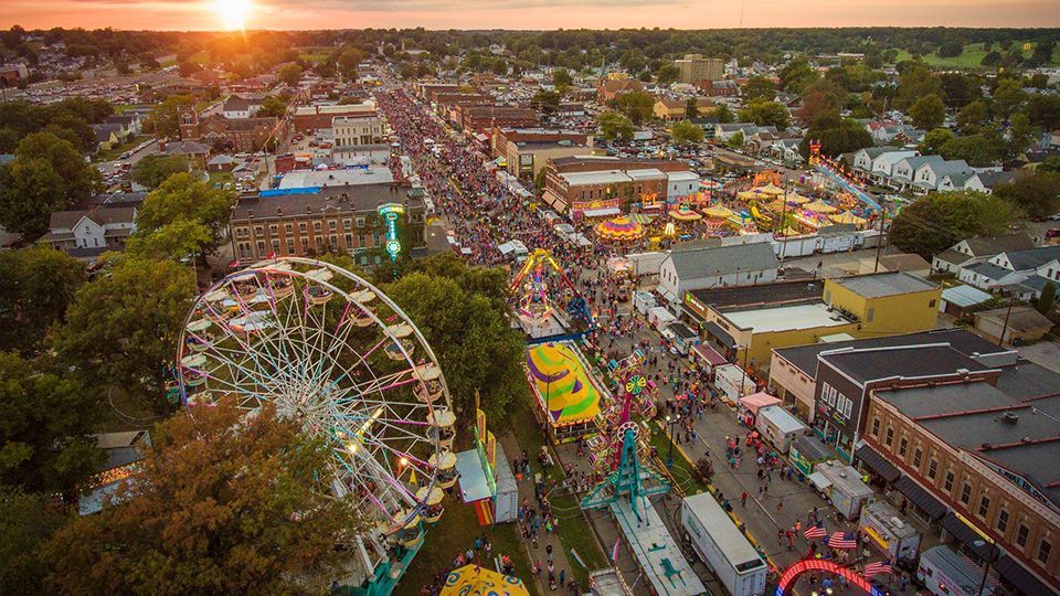A lot of cars are parked in front of a building
