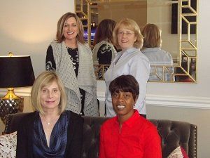 A group of women are posing for a picture in a living room.
