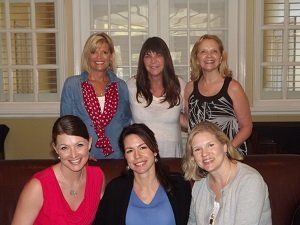 A group of women are posing for a picture in a living room