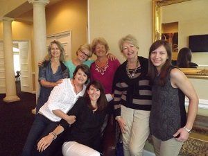 A group of women are posing for a picture in a room.