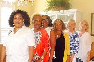 A group of women are posing for a picture in a living room.