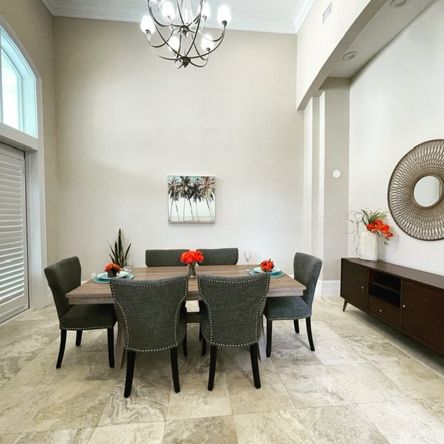 A dining room with a table and chairs and a chandelier