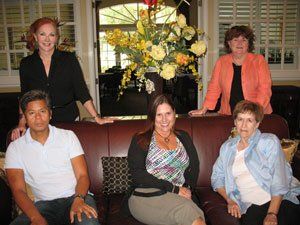 A group of people are posing for a picture while sitting on a couch