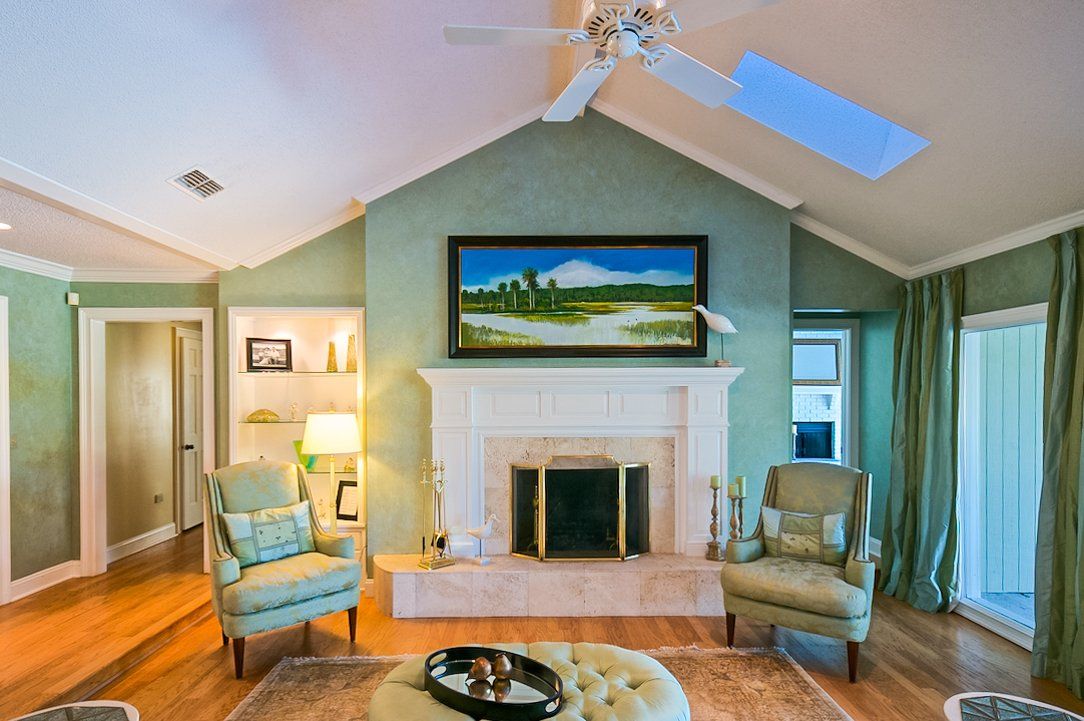 A living room with a fireplace and a ceiling fan