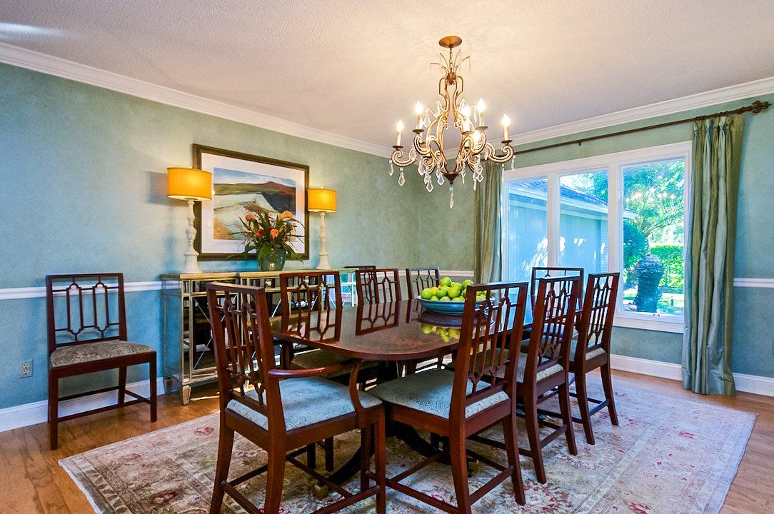 A dining room with a table and chairs and a chandelier.