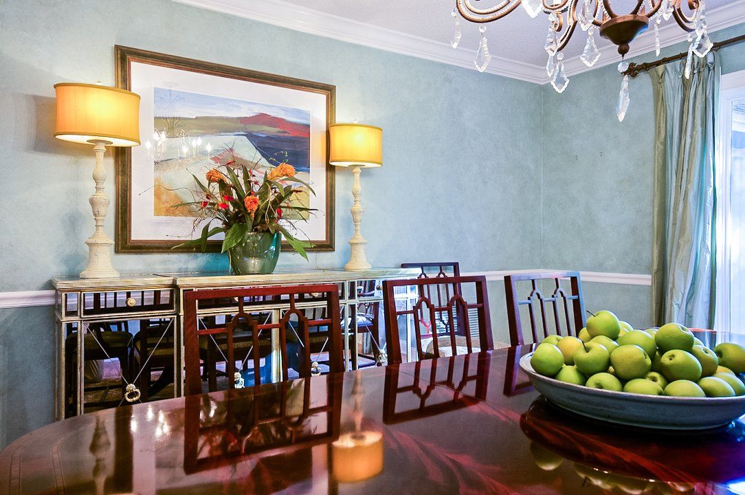 There is a bowl of apples on the table in the dining room.