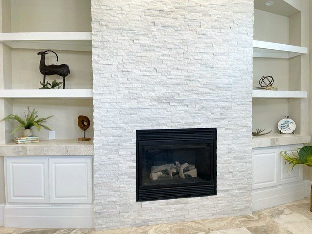 A living room with a fireplace and shelves