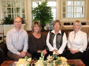 A group of people sitting around a table with flowers