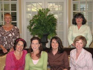 A group of women are posing for a picture in a living room