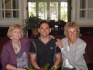 A man and two women are posing for a picture together