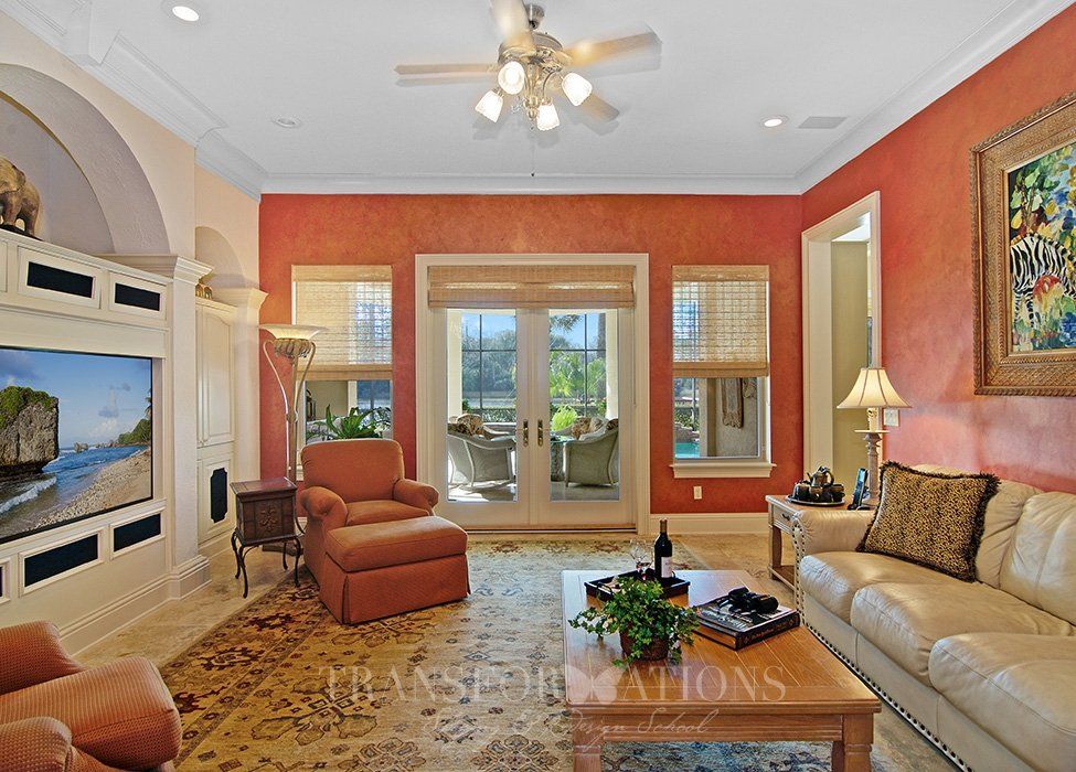 A living room with red walls and a ceiling fan