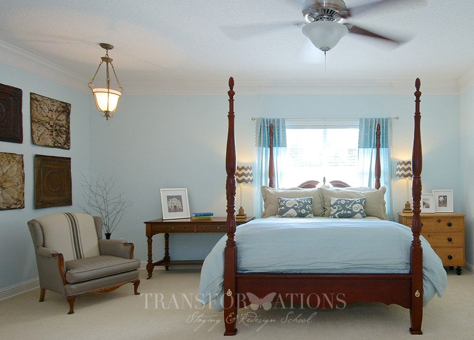 A bedroom with a four poster bed and a ceiling fan