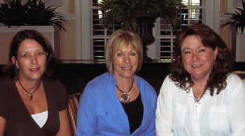 Three women are posing for a picture together in a room.