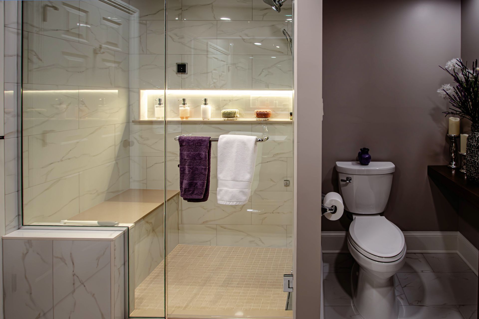 A bathroom with a toilet and a walk in shower.