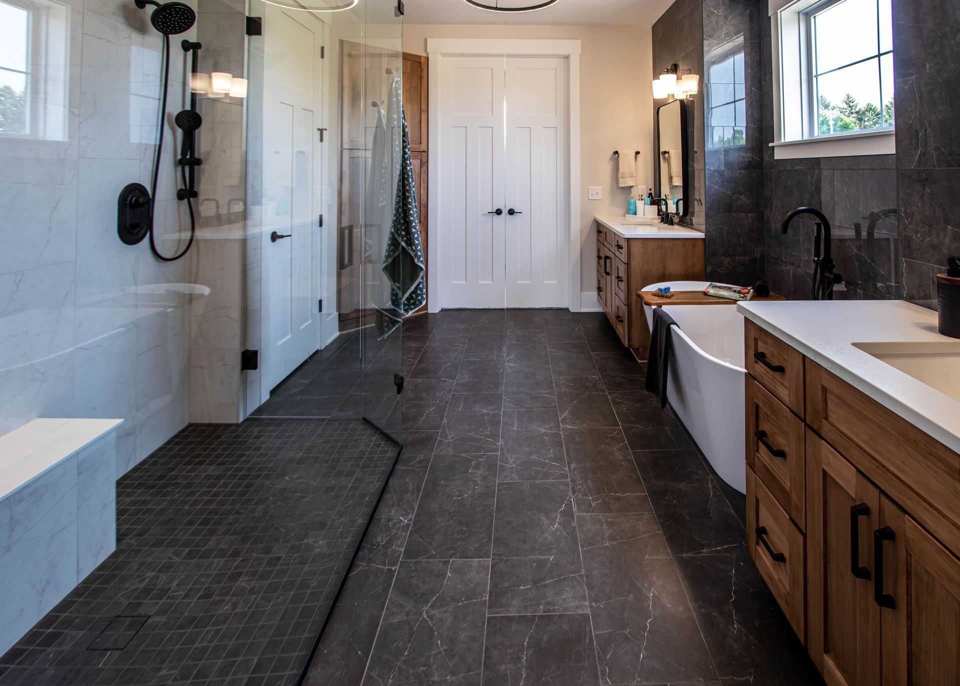 A bathroom with a tub , sink , shower and walk in shower.