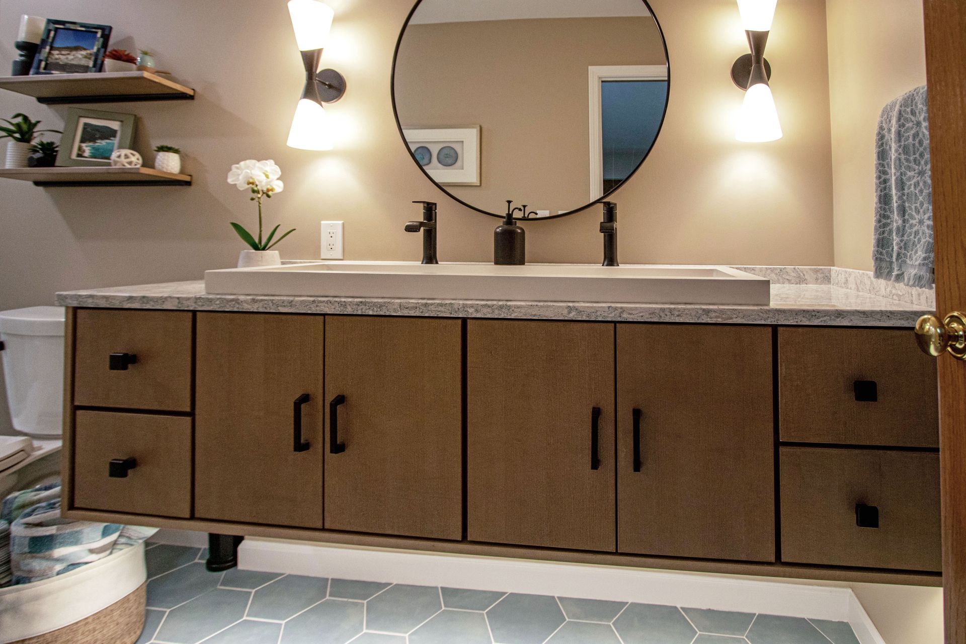 A bathroom with two sinks and a round mirror.