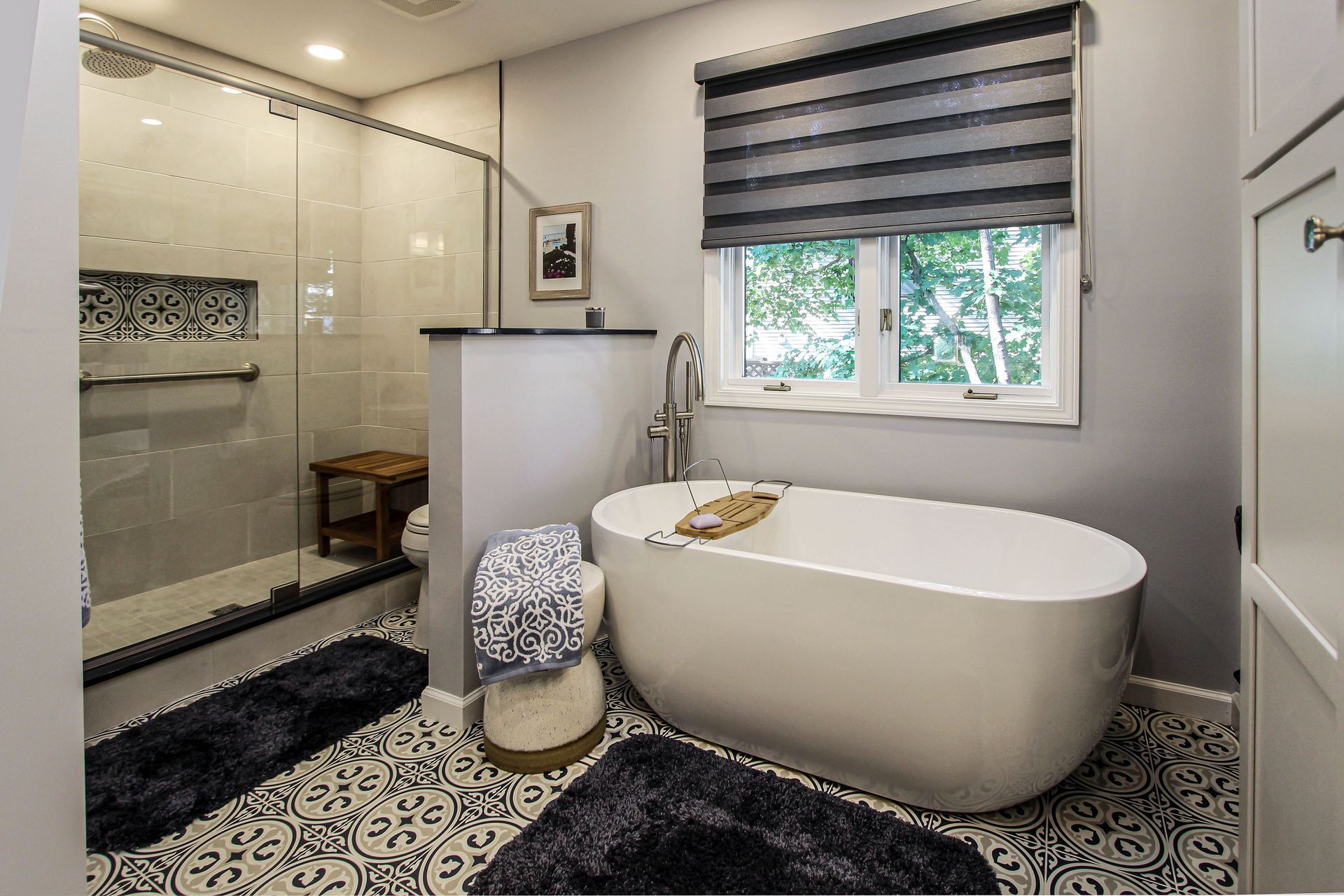 A bathroom with a tub , shower , and window.