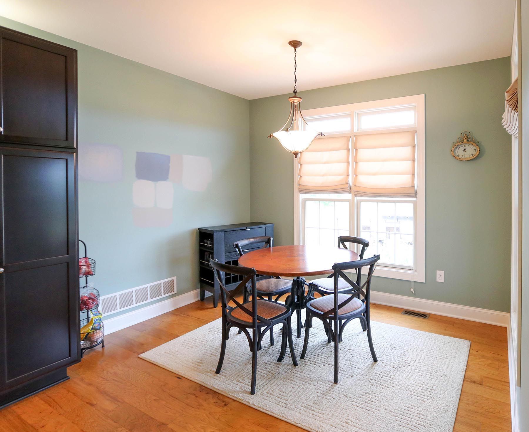 A dining room with a table and chairs and a rug