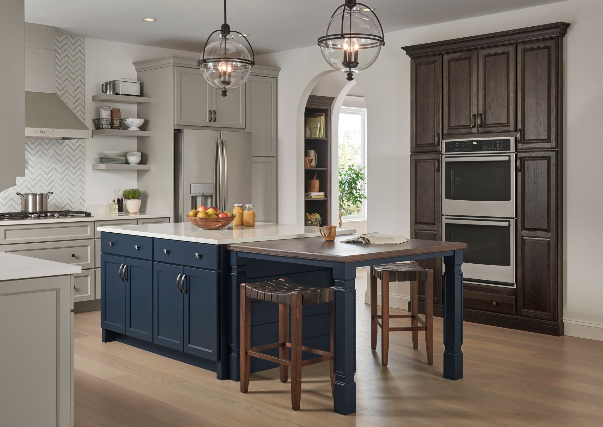 A kitchen with blue cabinets , stools , and a large island.