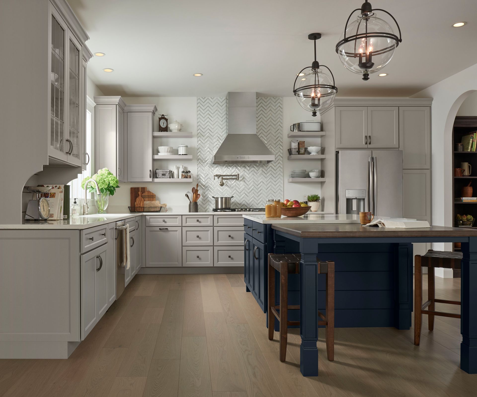 A kitchen with white cabinets and a blue island.