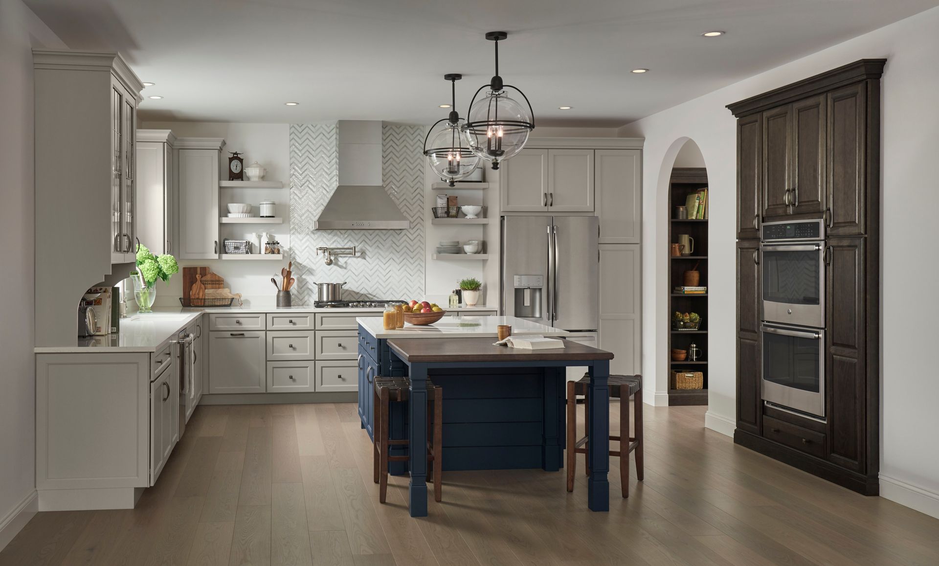 A kitchen with white cabinets and a blue island.