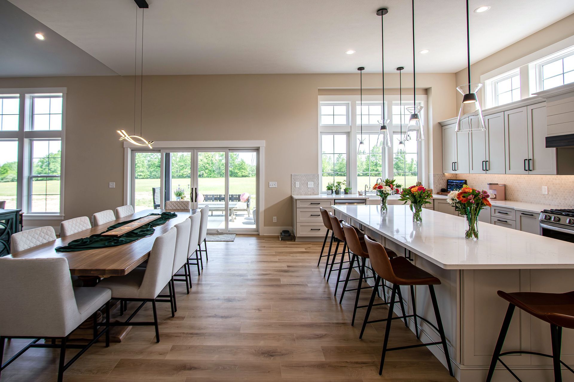 A kitchen and dining room in a house with a long table and chairs.