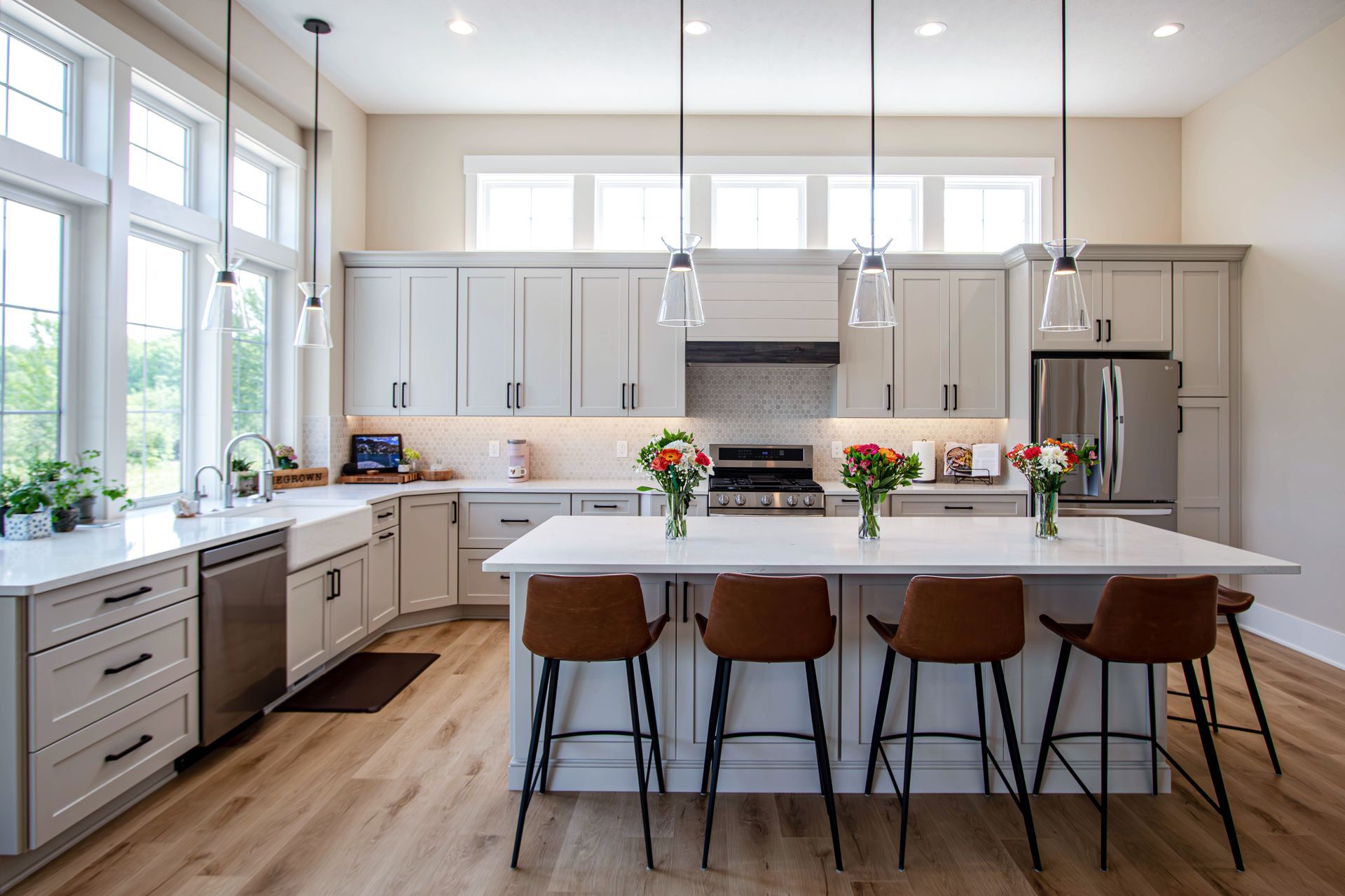 A kitchen with white cabinets , stainless steel appliances , and a large island.