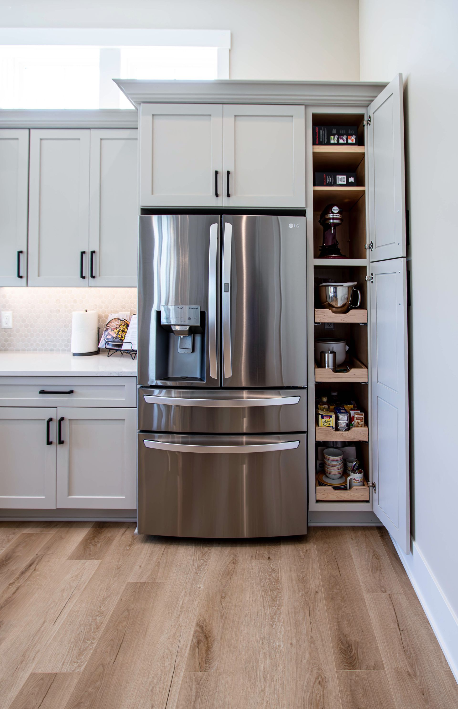 A kitchen with stainless steel appliances and white cabinets.