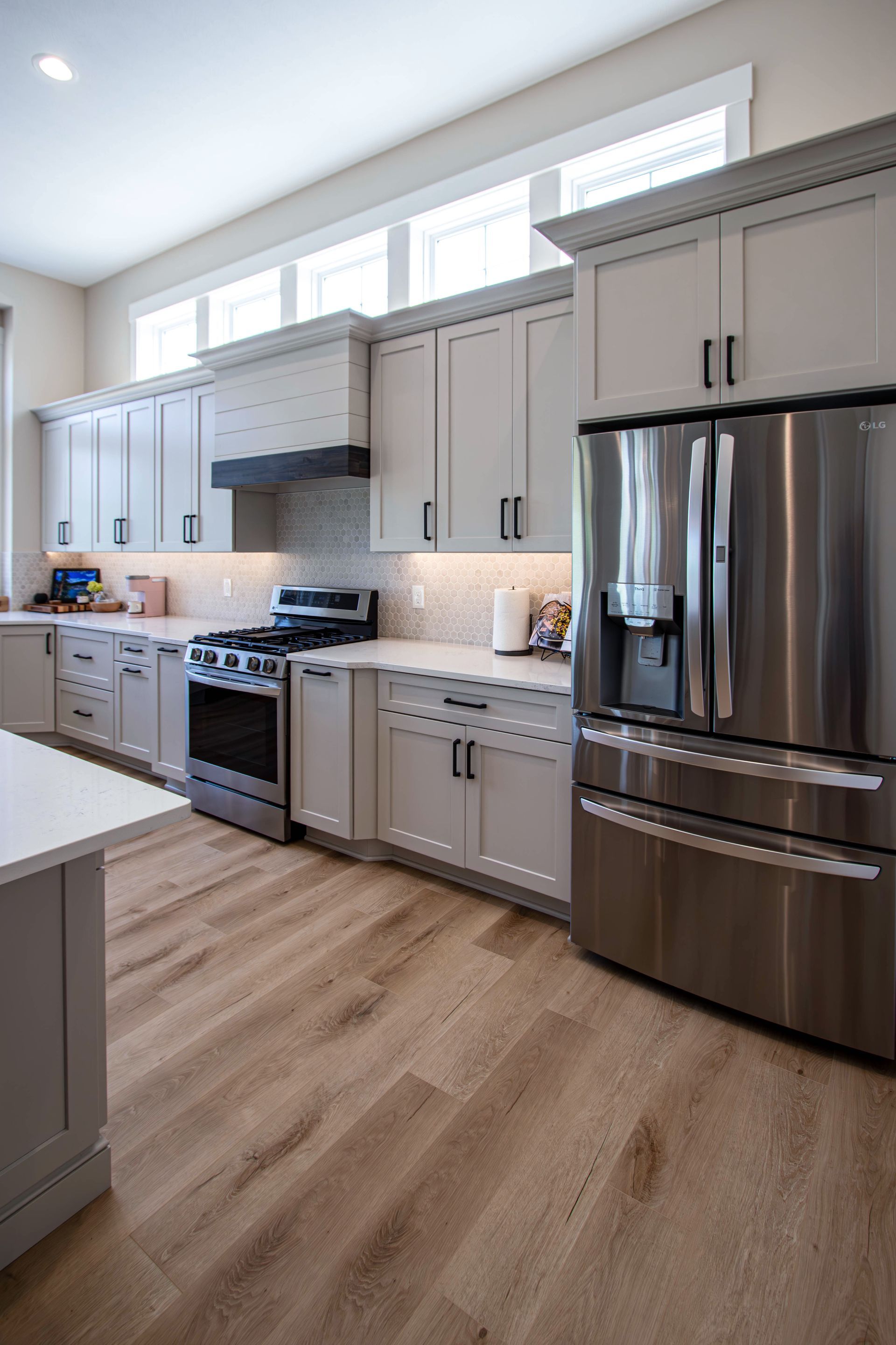 A kitchen with stainless steel appliances and white cabinets.
