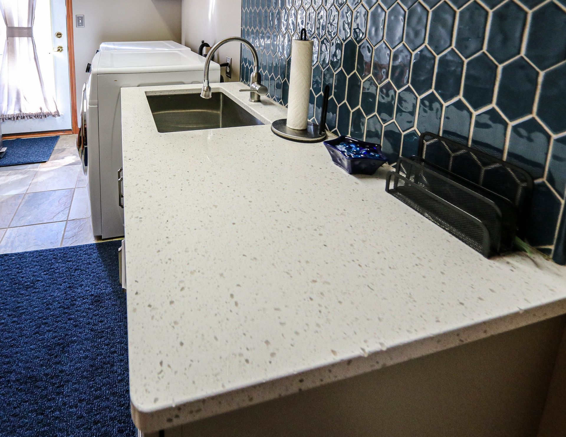 A kitchen counter with a sink and a paper towel holder