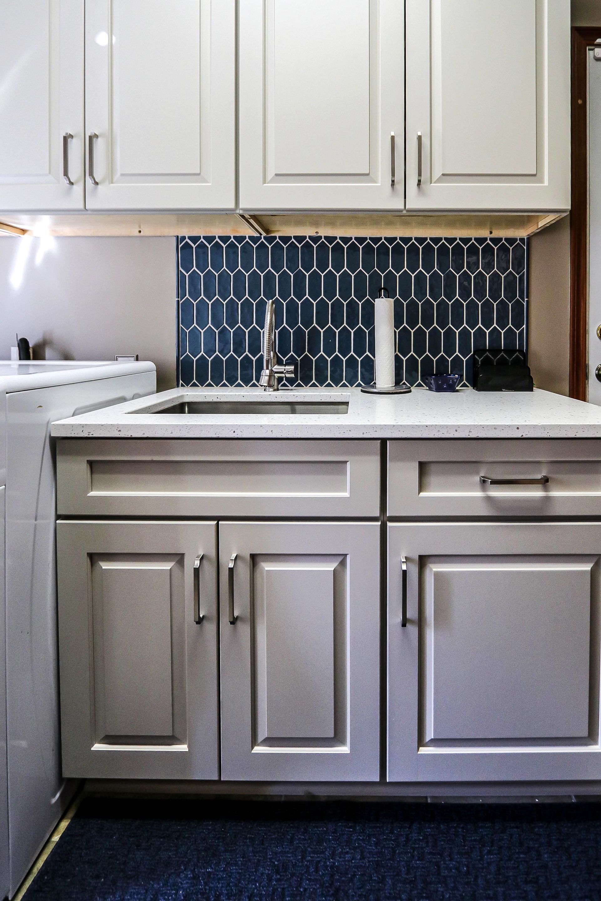 A kitchen with white cabinets and a sink