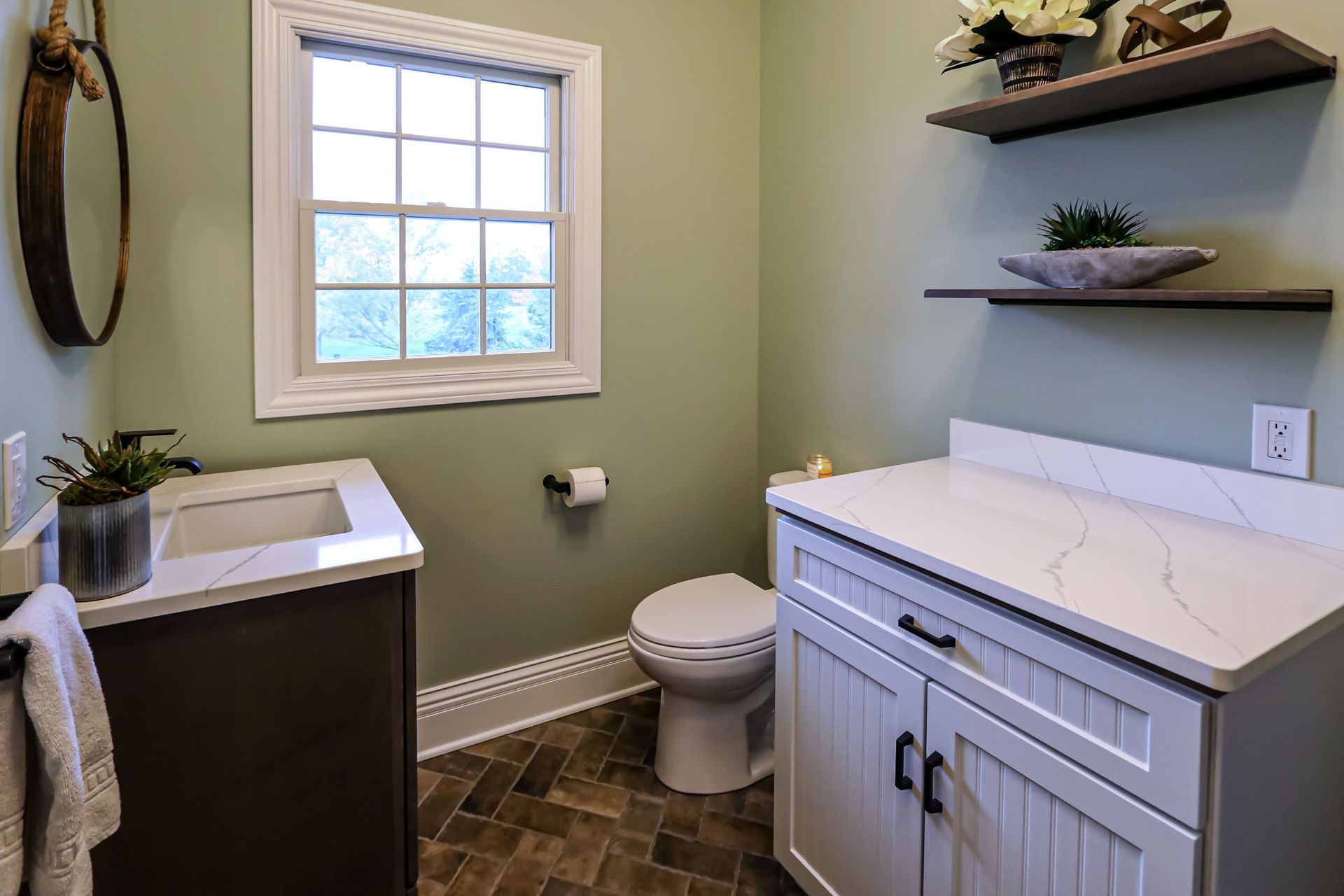 A bathroom with a sink , toilet , and window.