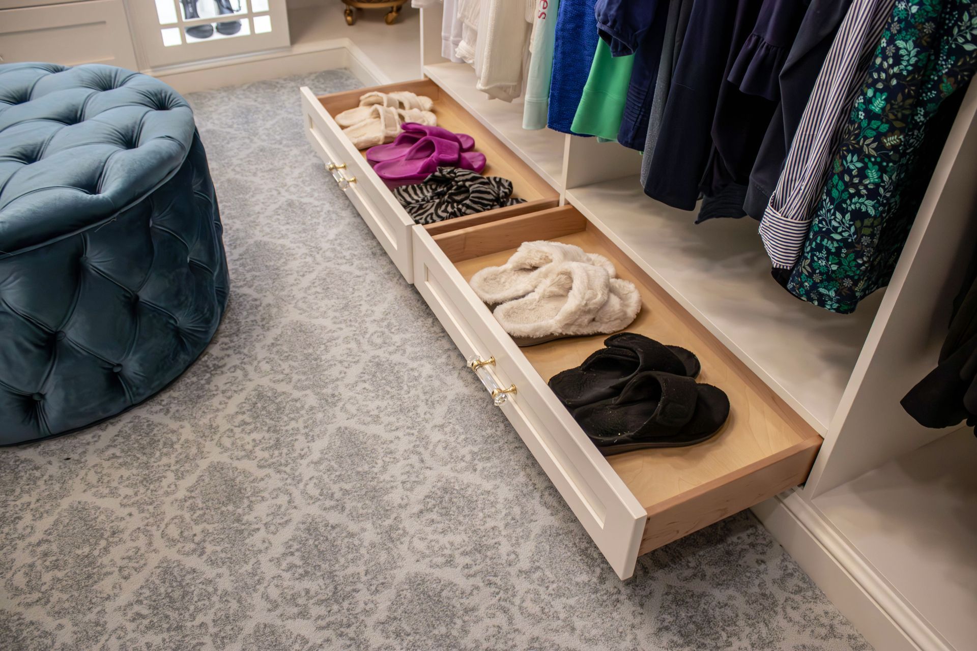 A closet with two drawers filled with clothes and shoes.
