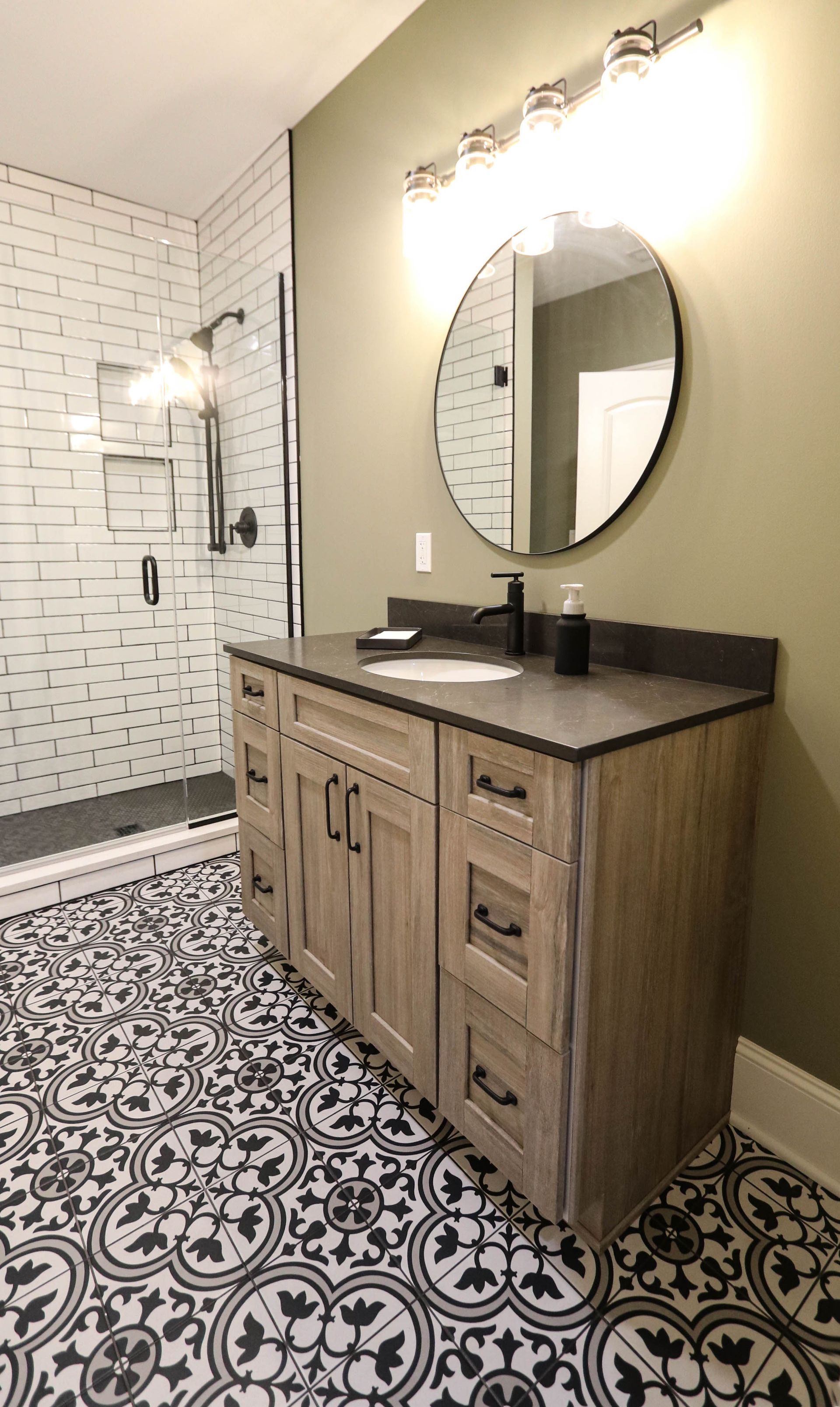 A bathroom with a sink , mirror , and shower.