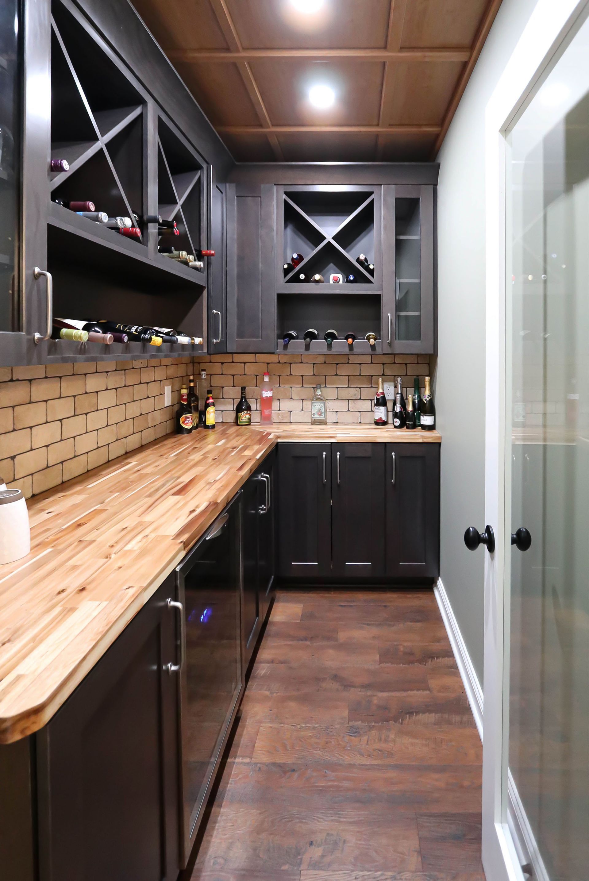 A kitchen with black cabinets and wooden counter tops